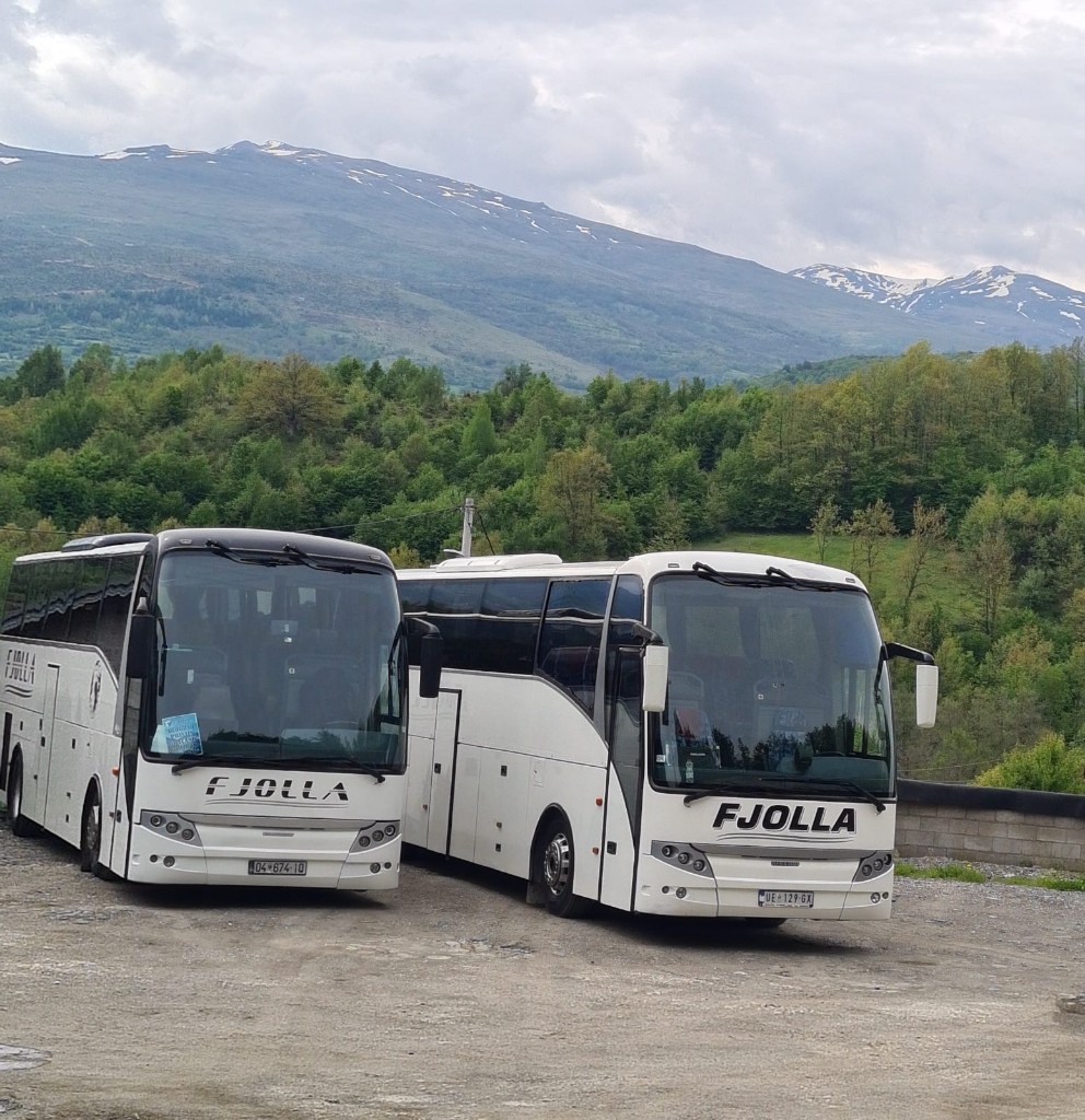Two Fjolla buses with mountain backdrop